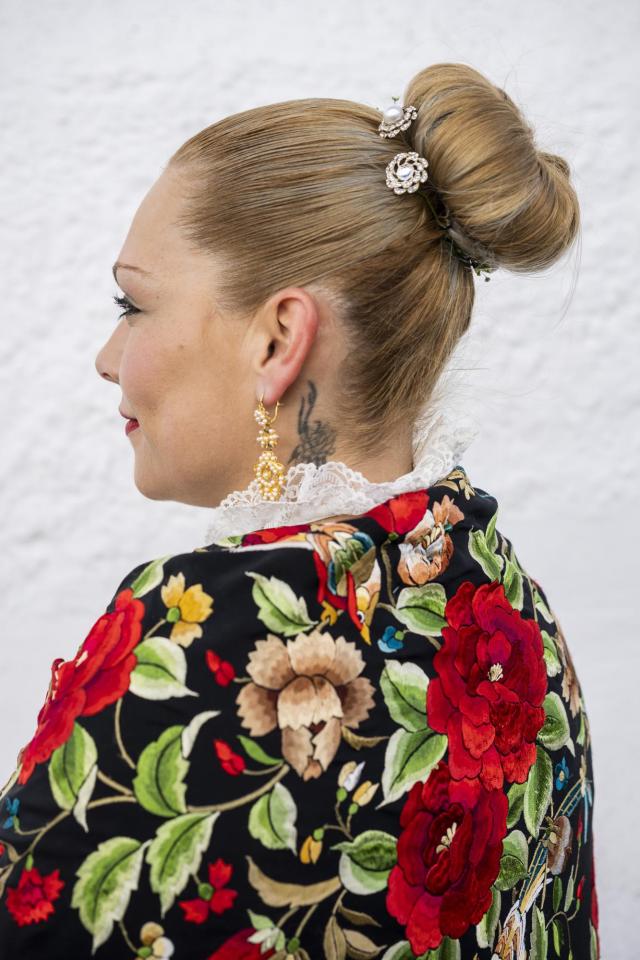 A woman dressed in traditional attire known as "regaora" poses for a portrait during the "Las Carantonas" festival in Acehuche, southeast Spain, Friday, Jan. 21, 2022. (AP Photo/Bernat Armangue)