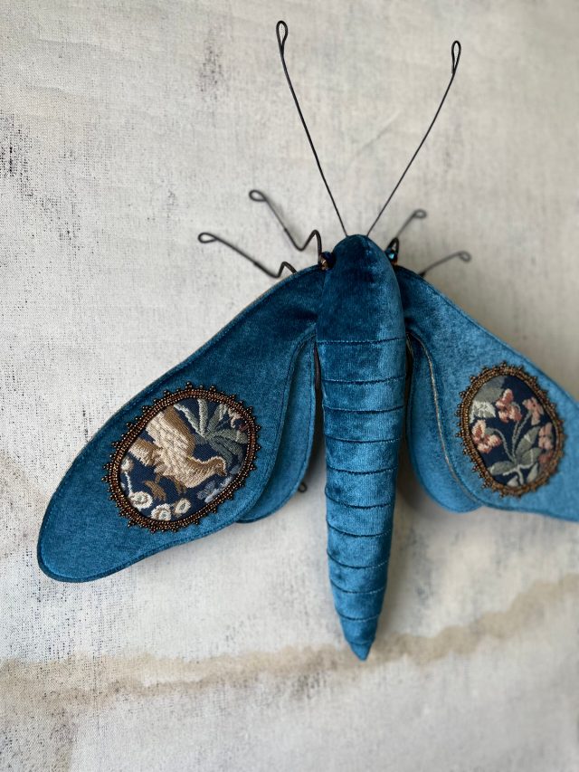 Plush moth sculptures embroidered with tapestry wings by Larysa Bernhardt