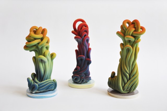 A photograph of three colourful sculptures, which appears like an organic plant-like form.