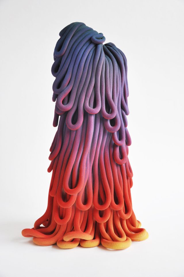 A photograph of a colourful sculpture, which appears like an organic plant-like form.